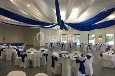 Parking vide avec marquages au sol, situé devant un bâtiment en bois entouré d'arbres et de montagnes.