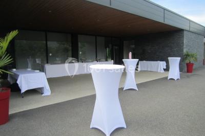 Parking vide avec marquages au sol, situé devant un bâtiment en bois entouré d'arbres et de montagnes.