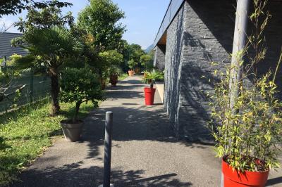 Parking vide avec marquages au sol, situé devant un bâtiment en bois entouré d'arbres et de montagnes.