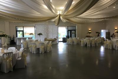 Parking vide avec marquages au sol, situé devant un bâtiment en bois entouré d'arbres et de montagnes.