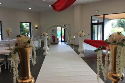 Parking vide avec marquages au sol, situé devant un bâtiment en bois entouré d'arbres et de montagnes.