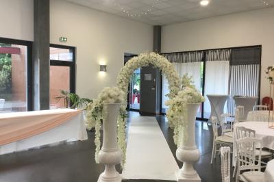 Parking vide avec marquages au sol, situé devant un bâtiment en bois entouré d'arbres et de montagnes.