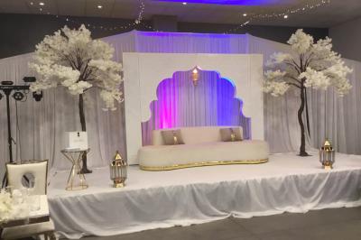 Parking vide avec marquages au sol, situé devant un bâtiment en bois entouré d'arbres et de montagnes.