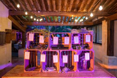 Salle de réception avec tables rondes dressées, nappes blanches, chaises en bois et décoration florale.