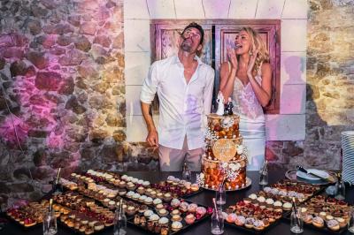 Salle de réception avec tables rondes dressées, nappes blanches, chaises en bois et décoration florale.
