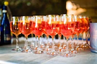 Salle de réception avec tables rondes dressées, nappes blanches, chaises en bois et décoration florale.