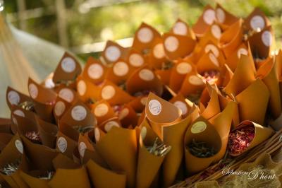 Salle de réception avec tables rondes dressées, nappes blanches, chaises en bois et décoration florale.