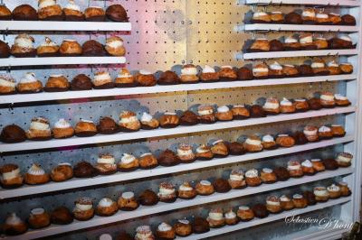 Salle de réception avec tables rondes dressées, nappes blanches, chaises en bois et décoration florale.