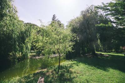 Salle de réception avec tables rondes dressées, nappes blanches, chaises en bois et décoration florale.