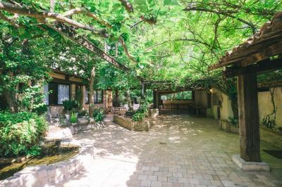 Salle de réception avec tables rondes dressées, nappes blanches, chaises en bois et décoration florale.