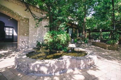 Salle de réception avec tables rondes dressées, nappes blanches, chaises en bois et décoration florale.