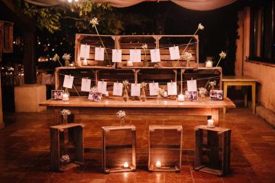 Salle de réception avec tables rondes dressées, nappes blanches, chaises en bois et décoration florale.