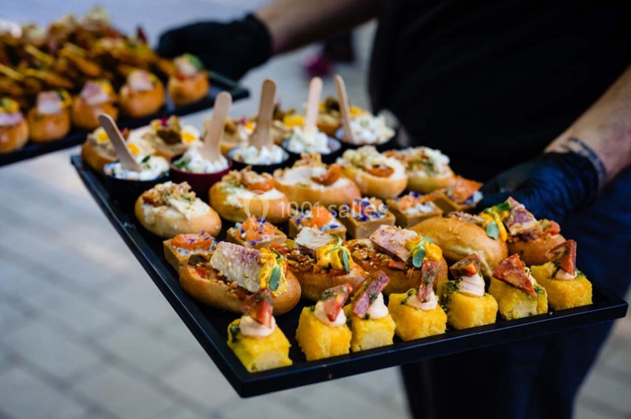 Plateau de bouchées apéritives variées, comprenant canapés, brochettes et amuse-bouches colorés.