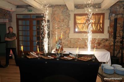 Salle de réception avec tables rondes dressées, nappes blanches, chaises en bois et décoration florale.