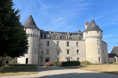 Miniature Location salle Marçay (Indre-et-Loire) - Château de Marcay #19 Chambre avec poutres apparentes, lit double, canapé beige, table basse en verre et murs décorés de papier peint.