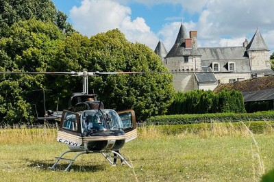 Miniature Location salle Marçay (Indre-et-Loire) - Château de Marcay #22 Chambre avec poutres apparentes, lit double, canapé beige, table basse en verre et murs décorés de papier peint.