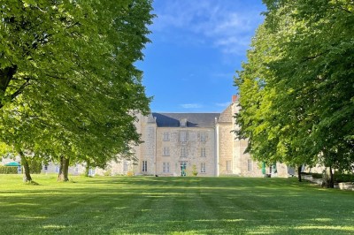 Miniature Location salle Marçay (Indre-et-Loire) - Château de Marcay #31 Chambre avec poutres apparentes, lit double, canapé beige, table basse en verre et murs décorés de papier peint.