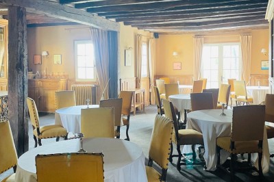 Miniature Location salle Marçay (Indre-et-Loire) - Château de Marcay #55 Chambre avec poutres apparentes, lit double, canapé beige, table basse en verre et murs décorés de papier peint.