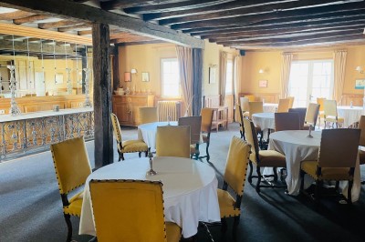 Miniature Location salle Marçay (Indre-et-Loire) - Château de Marcay #56 Chambre avec poutres apparentes, lit double, canapé beige, table basse en verre et murs décorés de papier peint.