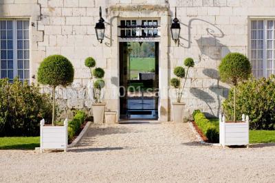 Miniature Location salle Marçay (Indre-et-Loire) - Château de Marcay #6 Chambre avec poutres apparentes, lit double, canapé beige, table basse en verre et murs décorés de papier peint.