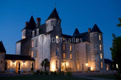 Miniature Location salle Marçay (Indre-et-Loire) - Château de Marcay #7 Chambre avec poutres apparentes, lit double, canapé beige, table basse en verre et murs décorés de papier peint.