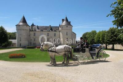 Miniature Location salle Marçay (Indre-et-Loire) - Château de Marcay #12 Chambre avec poutres apparentes, lit double, canapé beige, table basse en verre et murs décorés de papier peint.