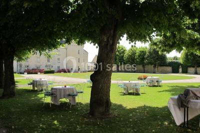 Miniature Location salle Marçay (Indre-et-Loire) - Château de Marcay #14 Chambre avec poutres apparentes, lit double, canapé beige, table basse en verre et murs décorés de papier peint.