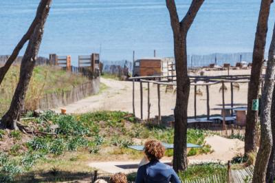 Table dressée avec assiettes en céramique, serviettes vertes pliées, couverts dorés, verres et décoration florale blanche.