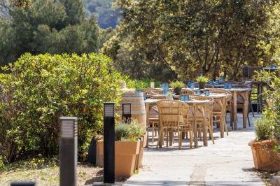Table dressée avec assiettes en céramique, serviettes vertes pliées, couverts dorés, verres et décoration florale blanche.