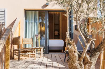 Table dressée avec assiettes en céramique, serviettes vertes pliées, couverts dorés, verres et décoration florale blanche.