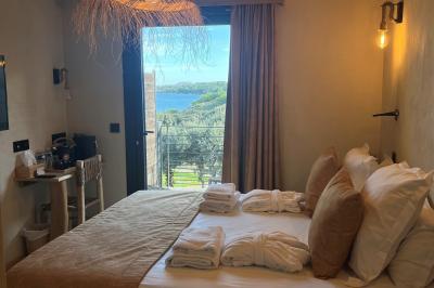 Table dressée avec assiettes en céramique, serviettes vertes pliées, couverts dorés, verres et décoration florale blanche.