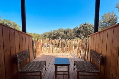 Table dressée avec assiettes en céramique, serviettes vertes pliées, couverts dorés, verres et décoration florale blanche.