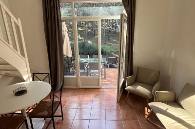 Table dressée avec assiettes en céramique, serviettes vertes pliées, couverts dorés, verres et décoration florale blanche.