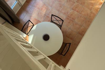 Table dressée avec assiettes en céramique, serviettes vertes pliées, couverts dorés, verres et décoration florale blanche.