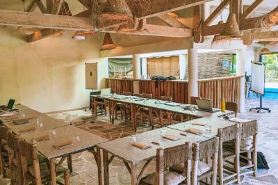 Table dressée avec assiettes en céramique, serviettes vertes pliées, couverts dorés, verres et décoration florale blanche.