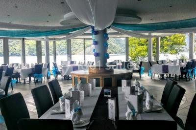 Intérieur d'un mobil-home lumineux avec cuisine équipée, vue sur une terrasse et paysage montagneux à l'extérieur.