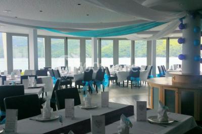 Intérieur d'un mobil-home lumineux avec cuisine équipée, vue sur une terrasse et paysage montagneux à l'extérieur.