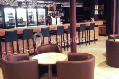 Intérieur d'un mobil-home lumineux avec cuisine équipée, vue sur une terrasse et paysage montagneux à l'extérieur.