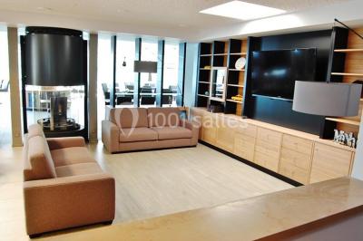 Intérieur d'un mobil-home lumineux avec cuisine équipée, vue sur une terrasse et paysage montagneux à l'extérieur.