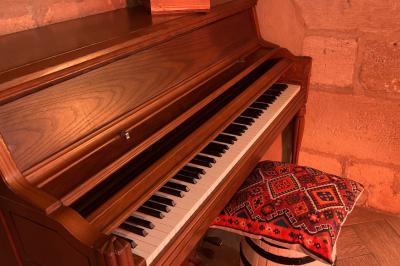 Fléchettes colorées dans une caisse en bois au premier plan, cible de jeu accrochée sur un mur en pierre en arrière-plan.