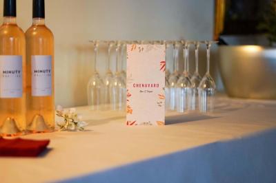 Salle lumineuse avec tables, chaises variées, baby-foot, miroir rond et murs en pierre apparente.