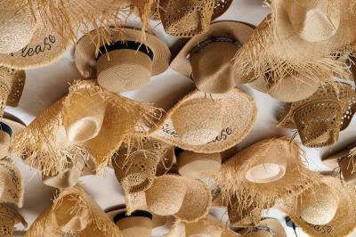 Salle lumineuse avec tables, chaises variées, baby-foot, miroir rond et murs en pierre apparente.