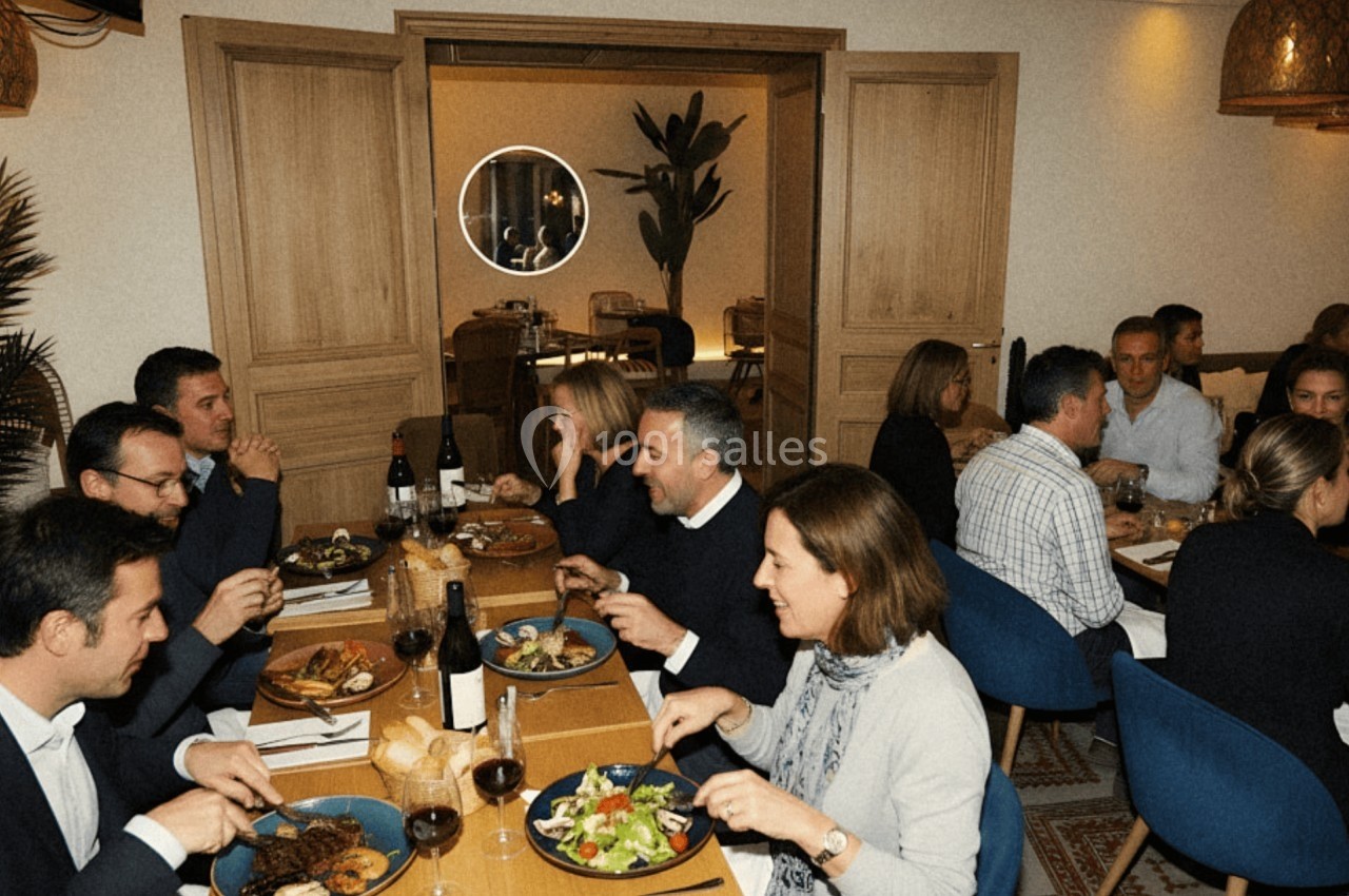 Des personnes dînent ensemble dans un restaurant, partageant un repas convivial autour de tables dressées.