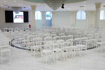 Un musicien joue du saxophone tandis qu'une femme en robe élégante danse avec enthousiasme dans un décor raffiné.