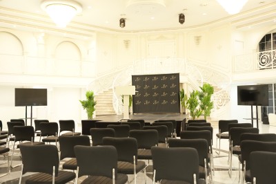 Table de billard bleu avec une queue et une bille, située dans une pièce lumineuse avec un baby-foot et de grandes baies…