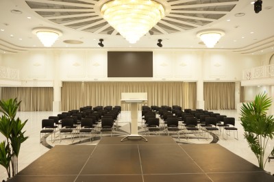 Table de billard bleu avec une queue et une bille, située dans une pièce lumineuse avec un baby-foot et de grandes baies…