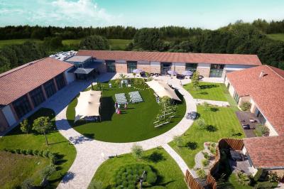 Salle de réception décorée pour un mariage, avec tables rondes, nappes blanches et guirlandes lumineuses au plafond.
