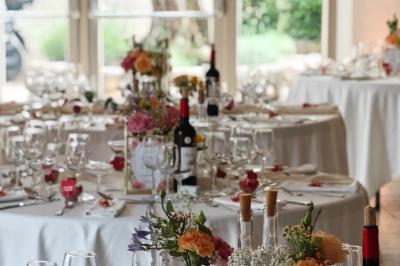 Un couple habillé élégamment, la femme en robe blanche et l'homme en costume, pose dans une pièce lumineuse.