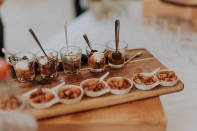 Un couple habillé élégamment, la femme en robe blanche et l'homme en costume, pose dans une pièce lumineuse.