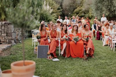 Un couple habillé élégamment, la femme en robe blanche et l'homme en costume, pose dans une pièce lumineuse.